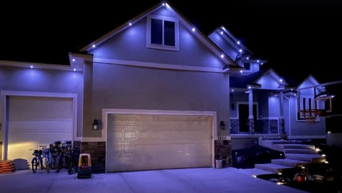 Salt Lake City home lit with blue color mode showing how dramatic permanent lighting color choices change a home's appearance at night