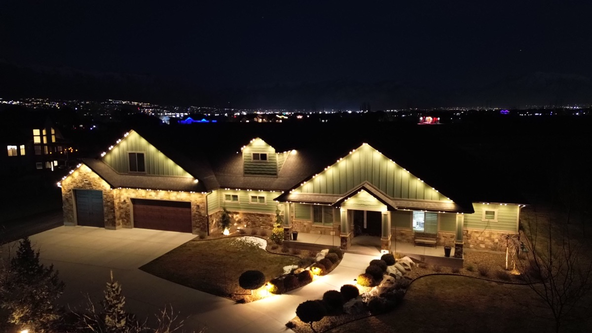 Luxury Wasatch Front ranch home illuminated with warm white permanent lighting at dusk showing how the right color temperature flatters stone and stucco