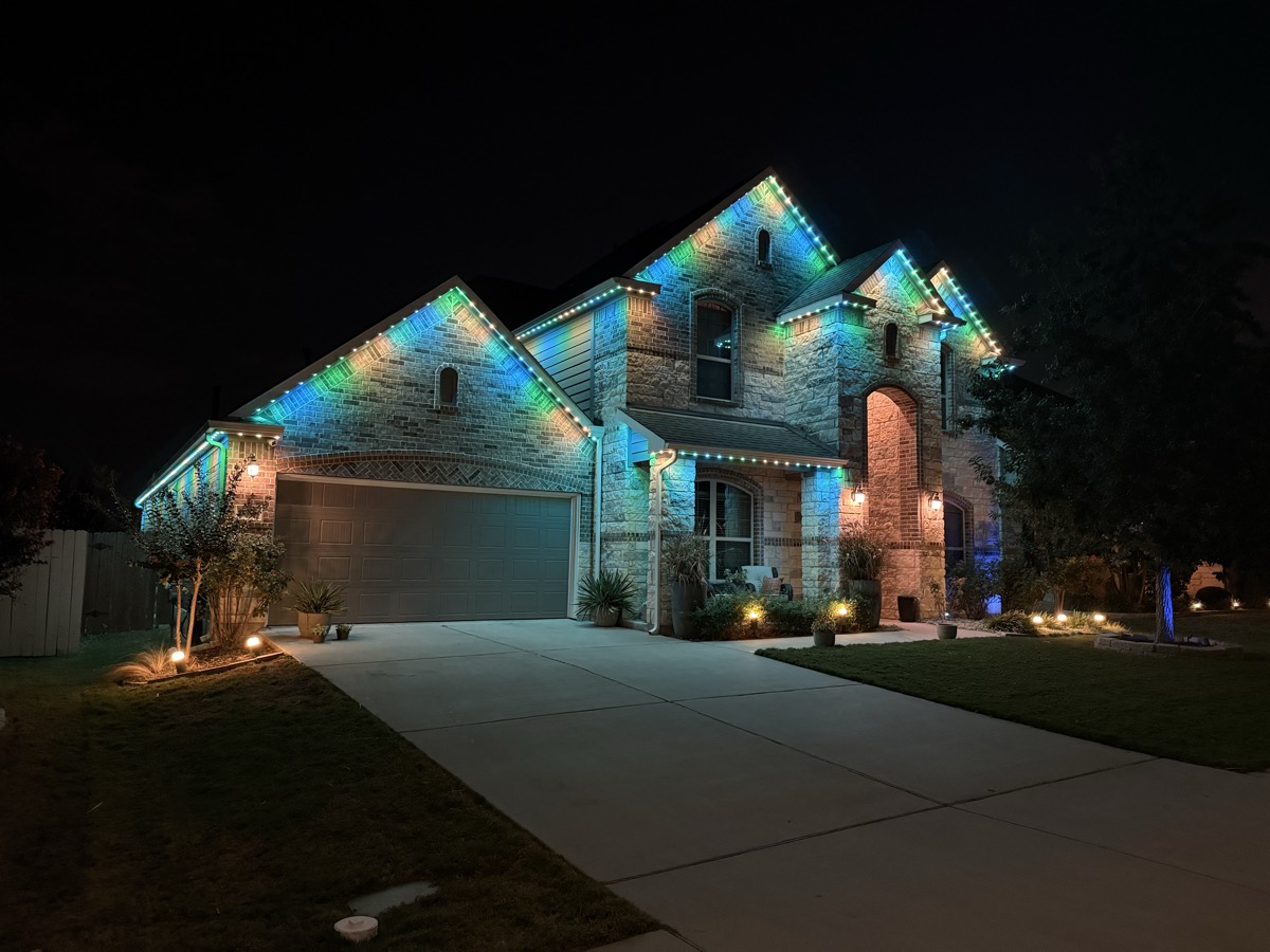 Austin home with TruLight 48-volt permanent lighting illuminating the long roofline at night
