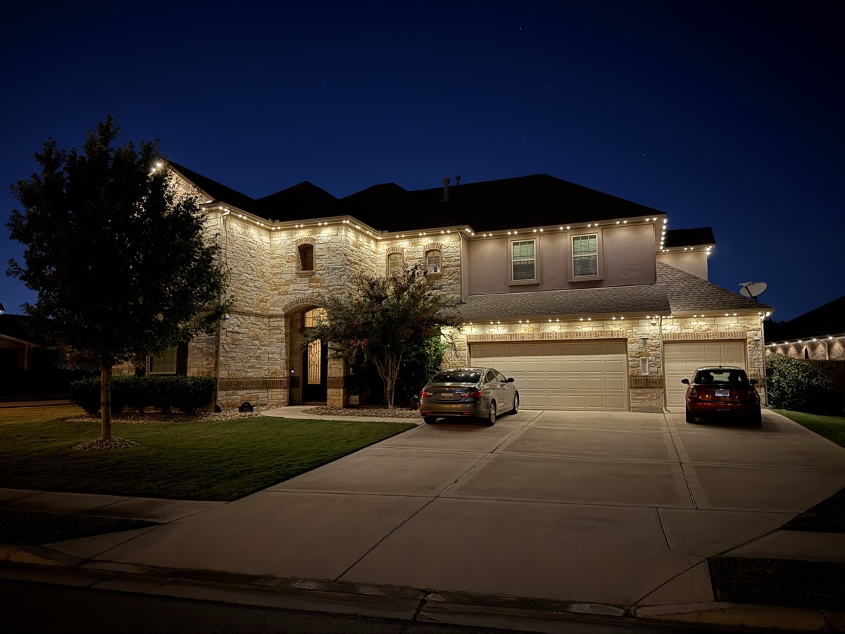 Austin Hill Country stone home with permanent LED security lighting at dusk