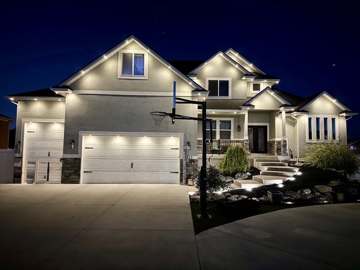 Salt Lake City stucco home with TruLight warm white permanent lighting at dusk