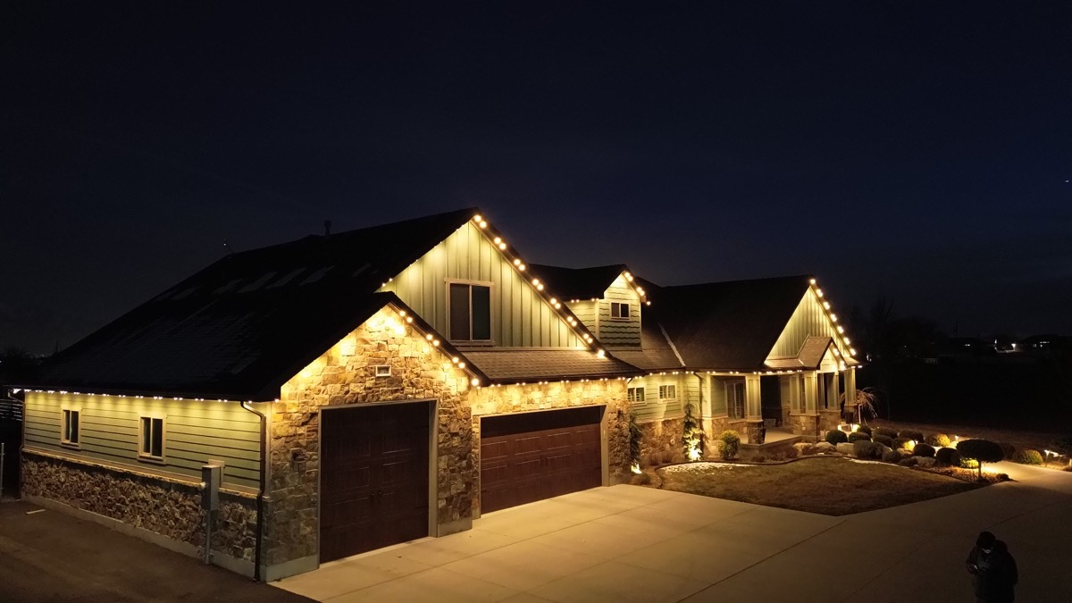 Salt Lake City home with TruLight permanent LED lighting showing warm white across the roofline at night